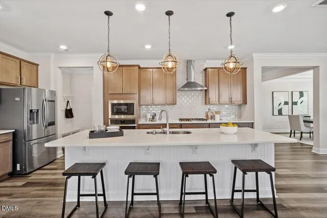 a kitchen with kitchen island granite countertop a sink a center island stainless steel appliances and cabinets