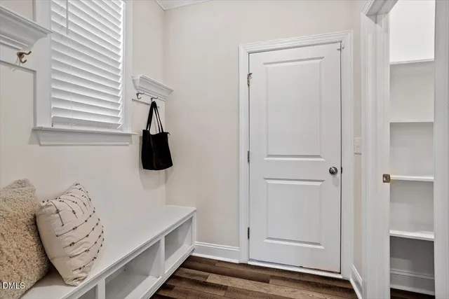 a living room with furniture large window and wooden floor