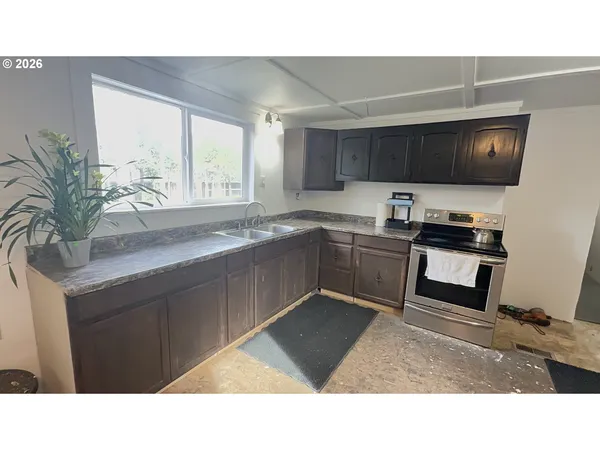 a kitchen with a sink a stove a microwave and cabinets