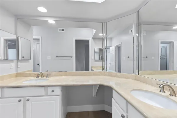 a bathroom with a sink double vanity granite tub shower and a mirror