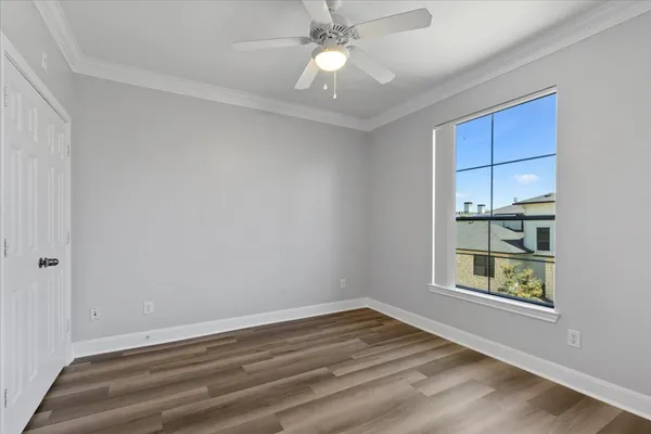 a view of an empty room with a window and closet area