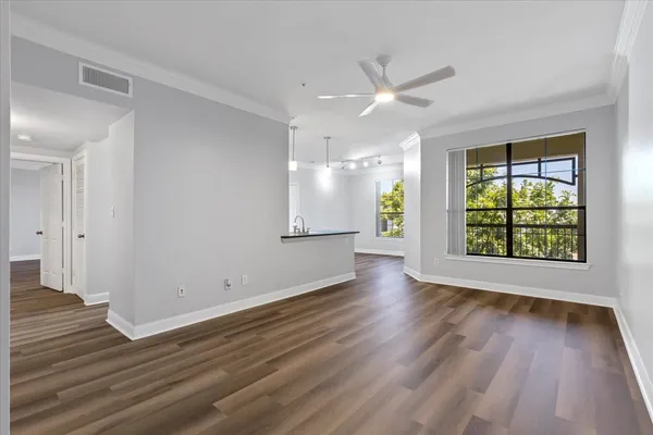 an empty room with wooden floor and windows