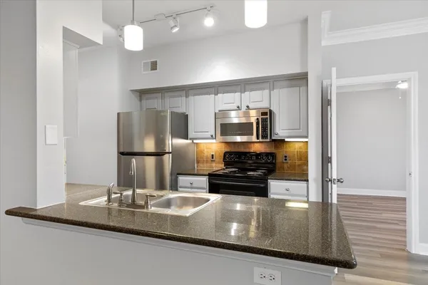 a kitchen with kitchen island a counter top a stove and a refrigerator