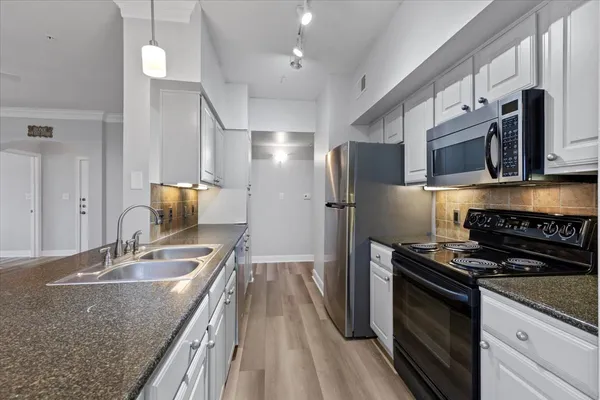 a kitchen with stainless steel appliances granite countertop a sink stove and refrigerator