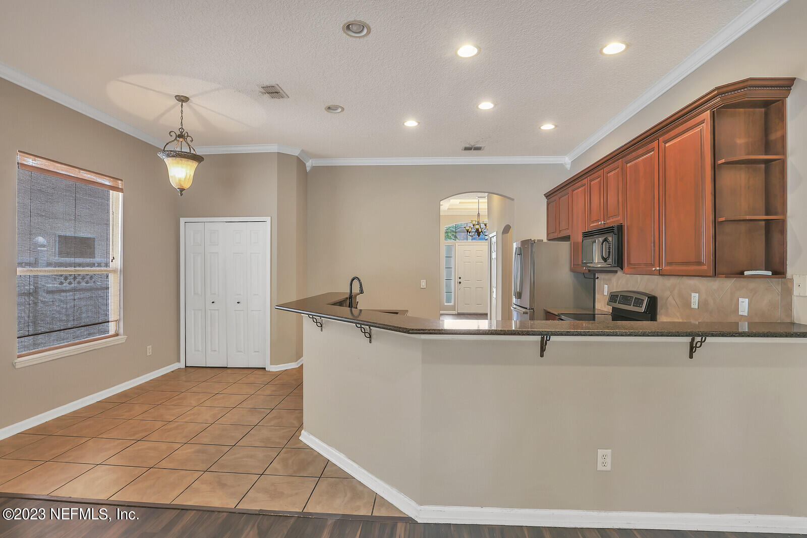 860 Briarcreek Road Jacksonville, FL 32225 - Photo 4 of 24 a kitchen with stainless steel appliances a sink a stove a refrigerator cabinets and a dining table
