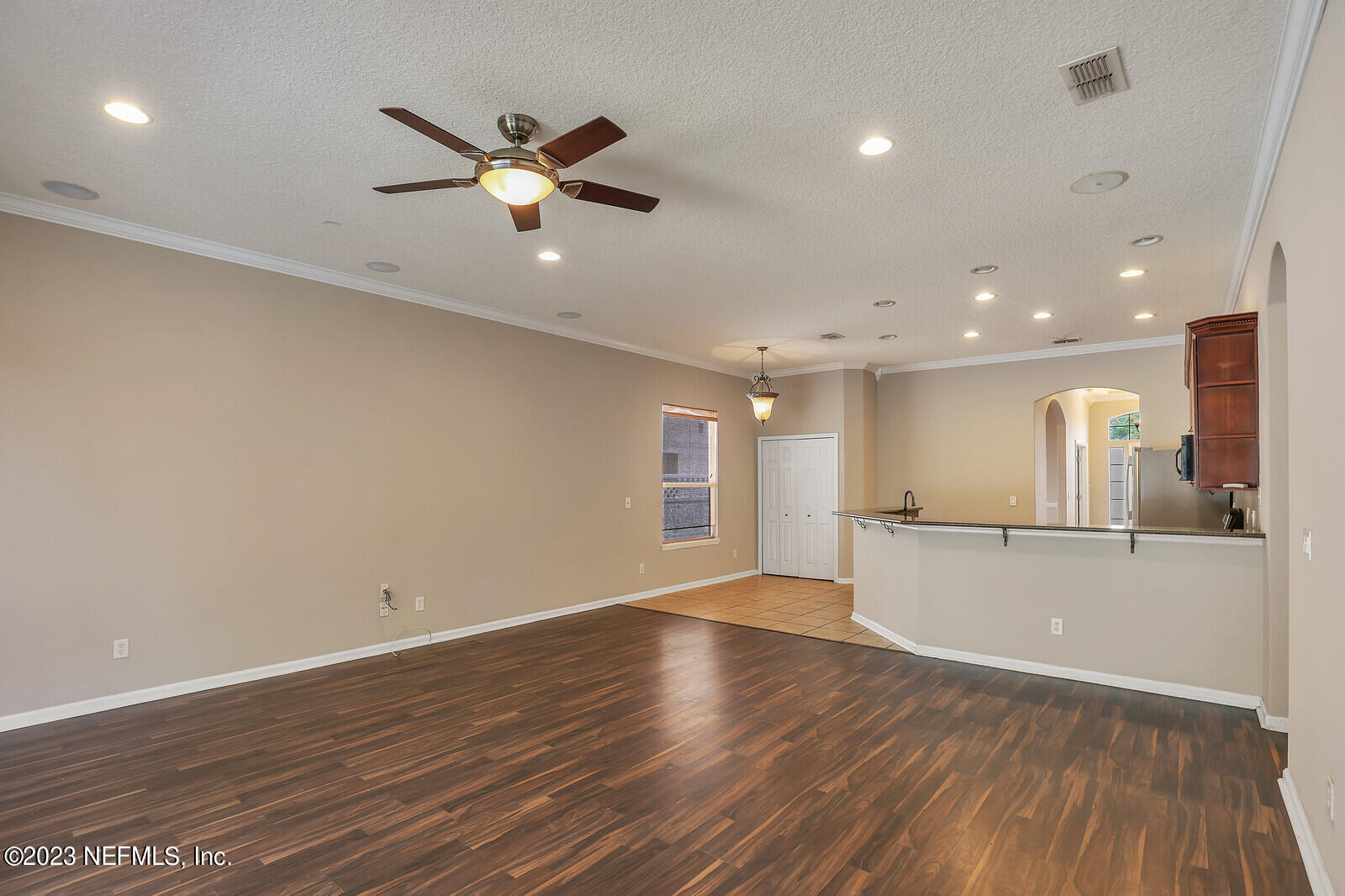 860 Briarcreek Road Jacksonville, FL 32225 - Photo 7 of 24 a view of an empty room with wooden floor and a ceiling fan