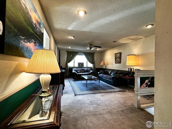 a living room with furniture gaming tables and a lamp