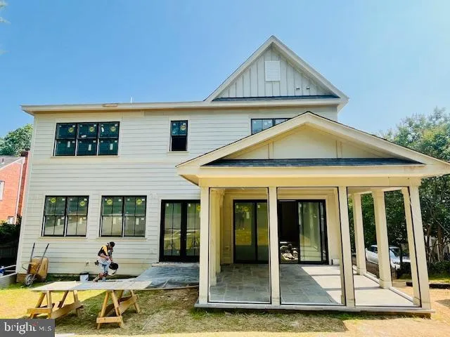a view of a house with large windows and couches chairs