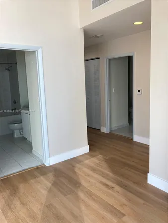 a view of a small space with wooden floor and a bathroom