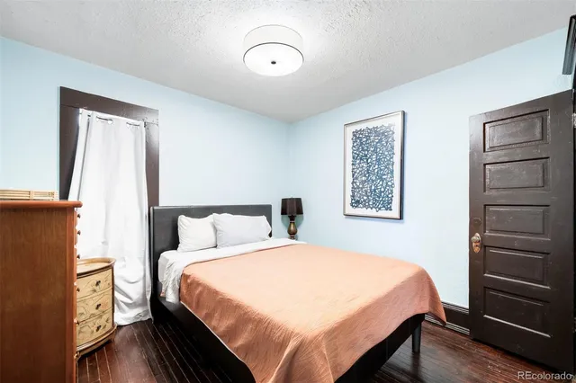 a bedroom with a bed and a flat tv screen on a dresser