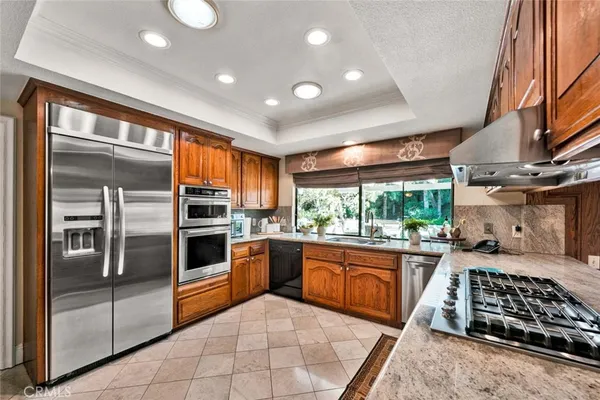 a kitchen with stainless steel appliances granite countertop a stove a sink and a refrigerator