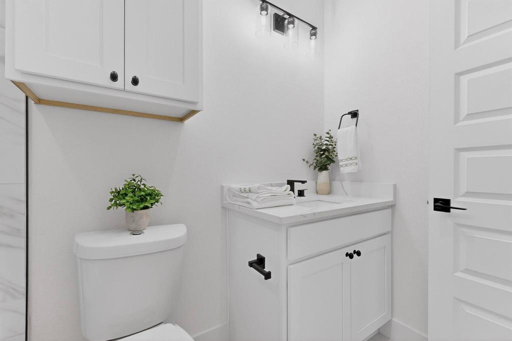 10169 Budtime Lane Dallas, TX 75217 - Photo 25 of 34 a bathroom with a sink a mirror and toilet