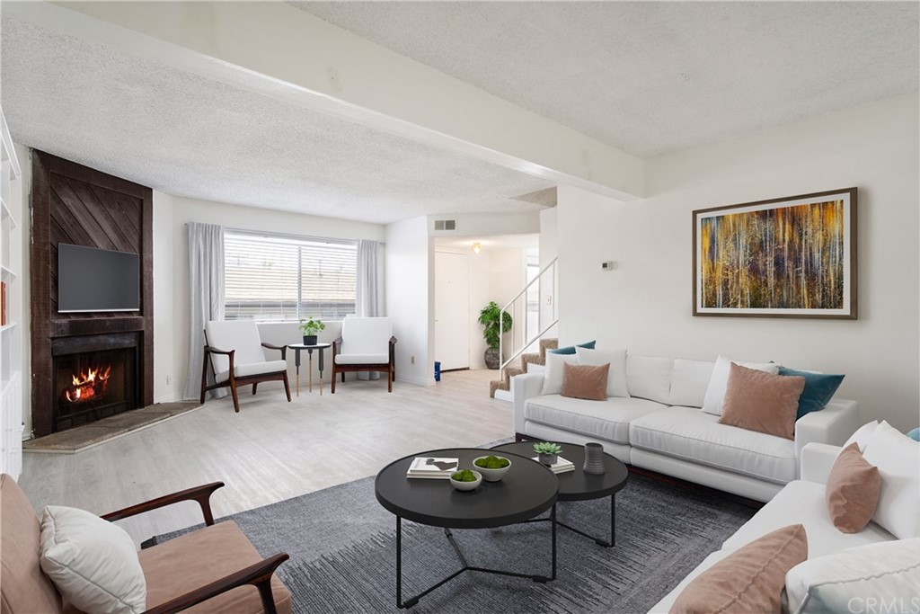 a living room with furniture a fireplace a flat screen tv and window