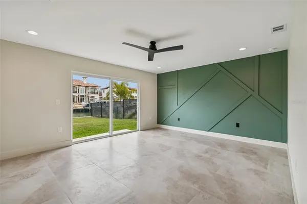 a view of a room with a ceiling fan and window in a room