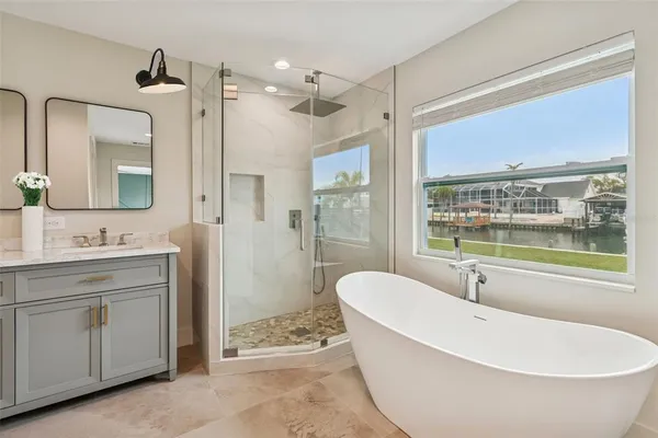 a spacious bathroom with a tub sink shower and mirror