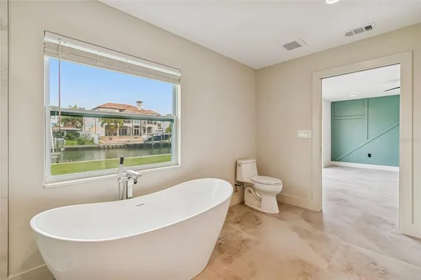 a bathroom with a white tub sitting next to a toilet