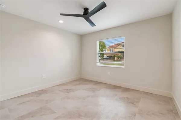 an empty room with windows and fan