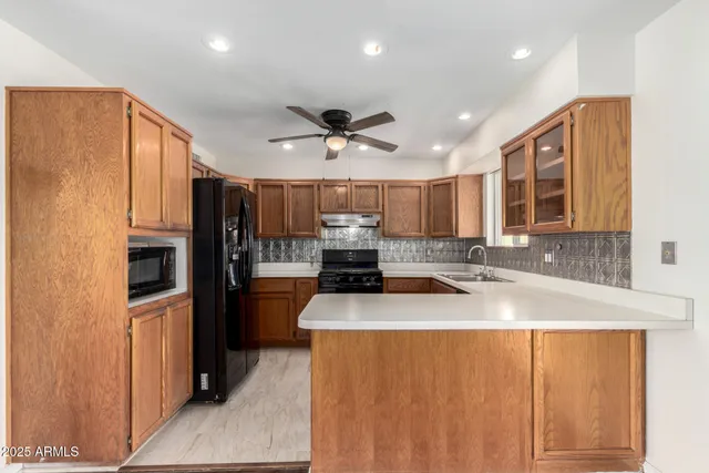 a kitchen with stainless steel appliances granite countertop a sink refrigerator and cabinets
