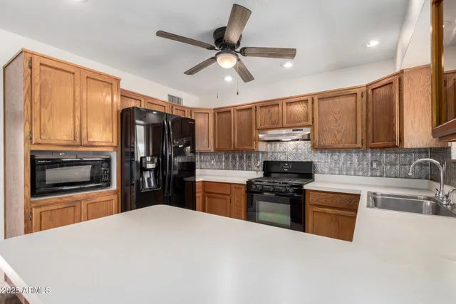 a kitchen with granite countertop wooden cabinets and stainless steel appliances