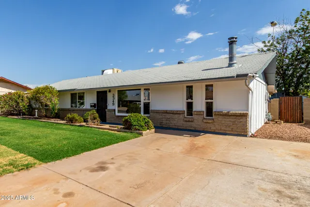 a front view of a house with a yard and potted plants