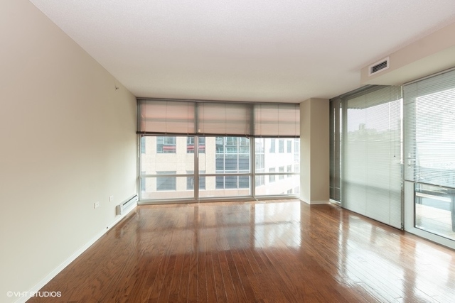 800 Elgin Road, Unit 519 Evanston, IL 60201 - Photo 2 of 17 a view of an empty room with wooden floor and a window