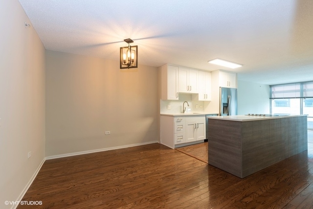 800 Elgin Road, Unit 519 Evanston, IL 60201 - Photo 3 of 17 a living room with kitchen island furniture and wooden floor