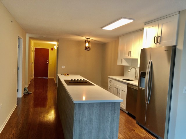 800 Elgin Road, Unit 519 Evanston, IL 60201 - Photo 5 of 17 a kitchen with a refrigerator a sink and wooden floor