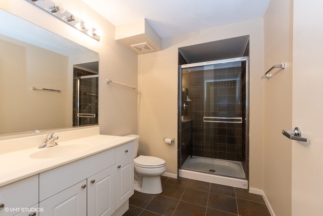 800 Elgin Road, Unit 519 Evanston, IL 60201 - Photo 7 of 17 a bathroom with a shower sink vanity and toilet