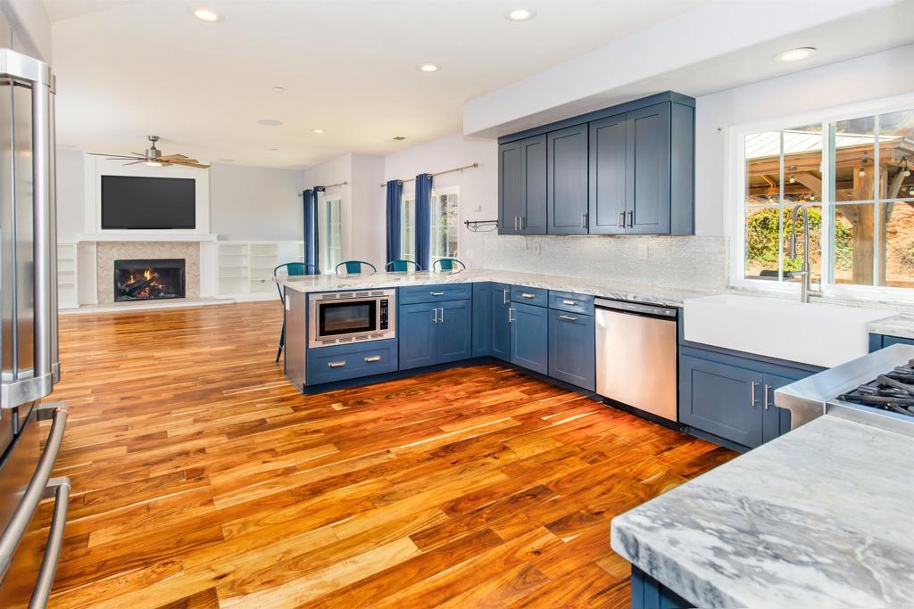 a kitchen with stainless steel appliances granite countertop a stove a sink and a microwave