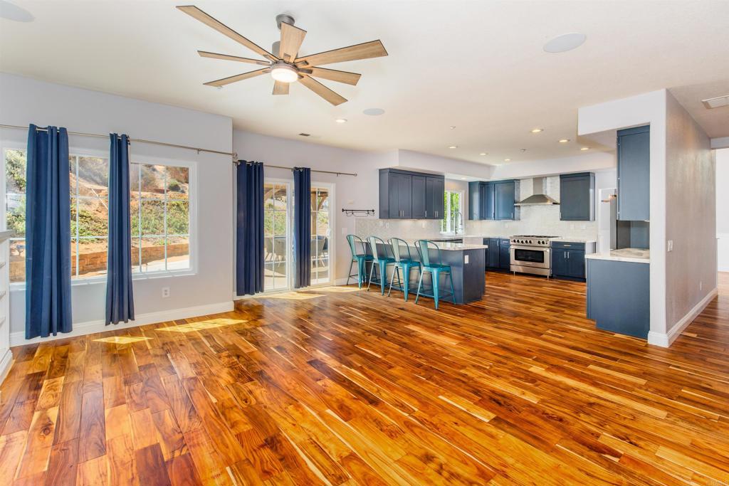 24427 Novato Place Ramona, CA 92065 - Photo 27 of 54 a large kitchen with stainless steel appliances kitchen island granite countertop a refrigerator and a stove top oven