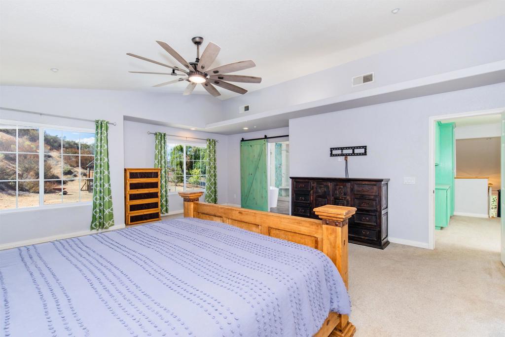 24427 Novato Place Ramona, CA 92065 - Photo 33 of 54 a bedroom with a bed and a chandelier