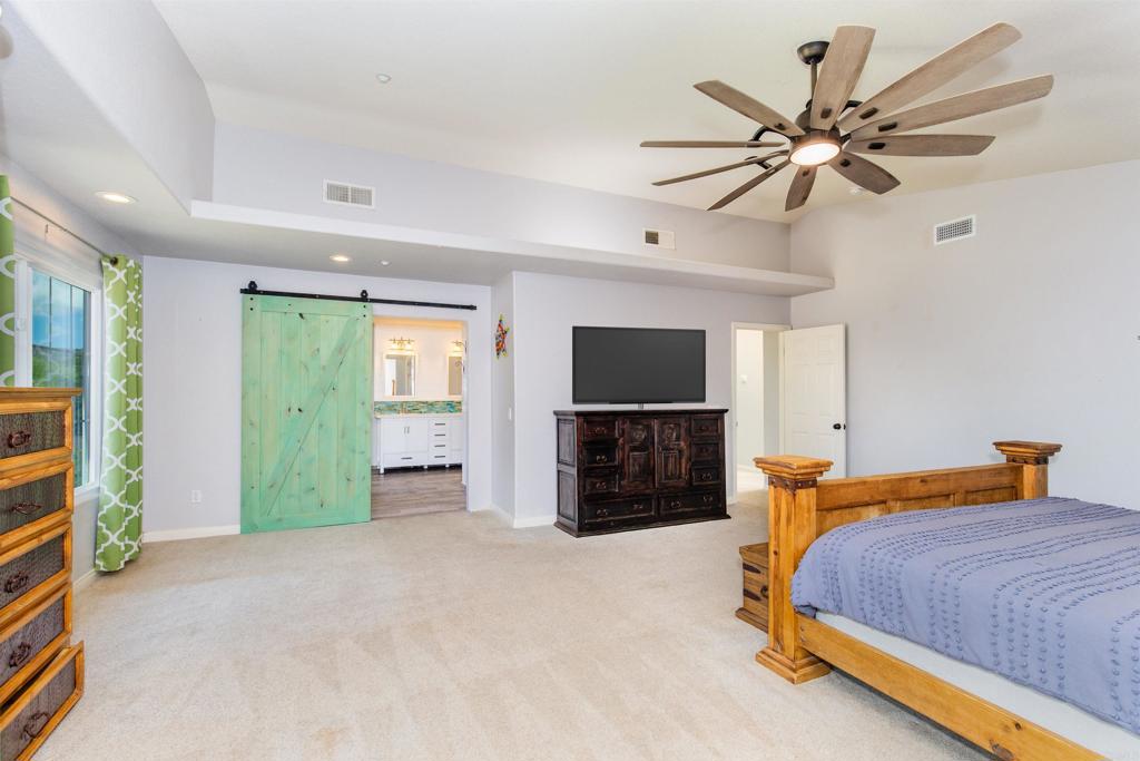 24427 Novato Place Ramona, CA 92065 - Photo 34 of 54 a bedroom with a bed and a flat screen tv