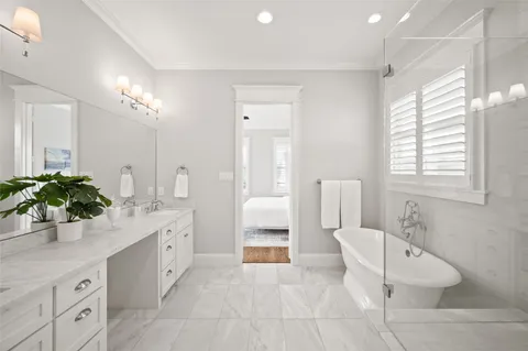 a spacious bathroom with a double vanity sink a large mirror a toilet and a shower