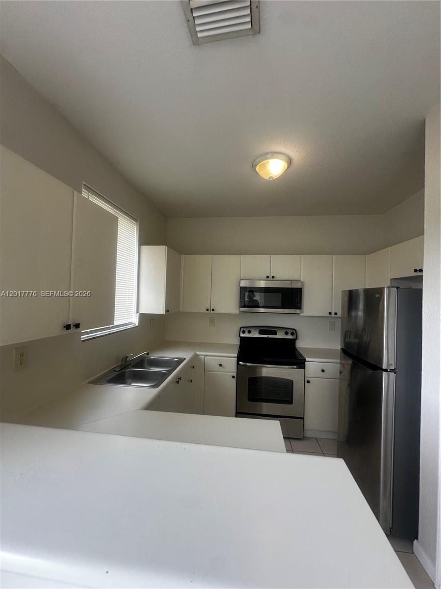 2907 Southeast 15th Road, Unit 67 Homestead, FL 33035 - Photo 4 of 25 a kitchen with a refrigerator stove and sink