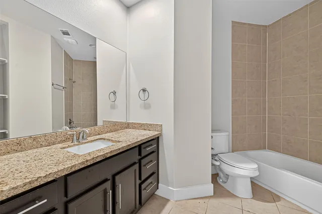 a bath tub sitting next to a white toilet and a shower