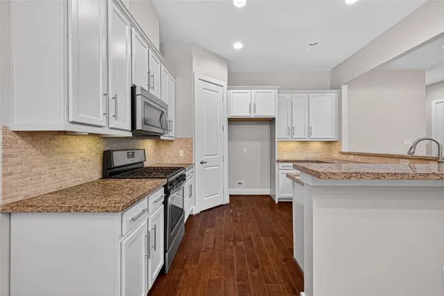 a kitchen with granite countertop a sink stove and refrigerator