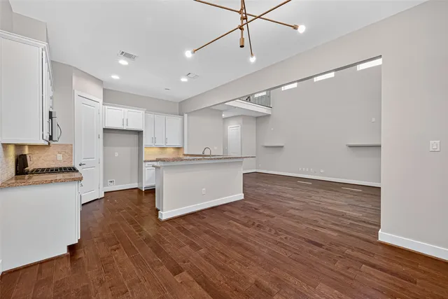 a kitchen with a refrigerator and white cabinets
