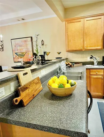 a view of a kitchen with kitchen island a stove a sink and a living room view