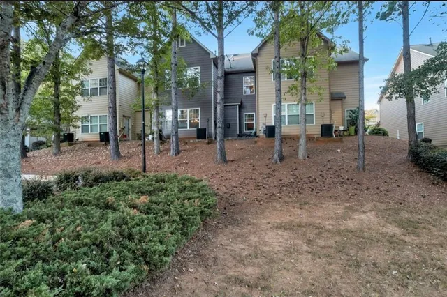 a view of a house with a backyard and tree
