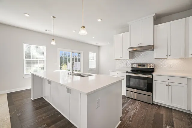 a kitchen with granite countertop a sink stainless steel appliances and cabinets