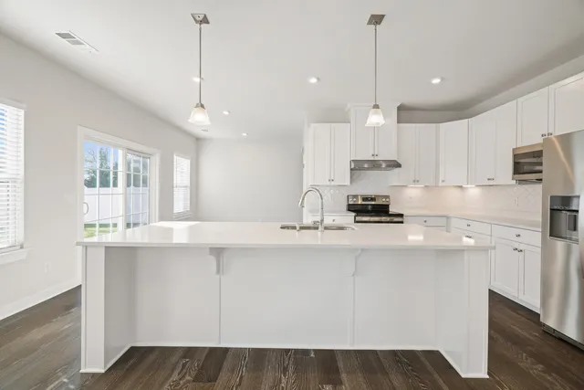 a kitchen with kitchen island white cabinets and white appliances