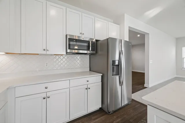 a kitchen with stainless steel appliances white cabinets and a refrigerator