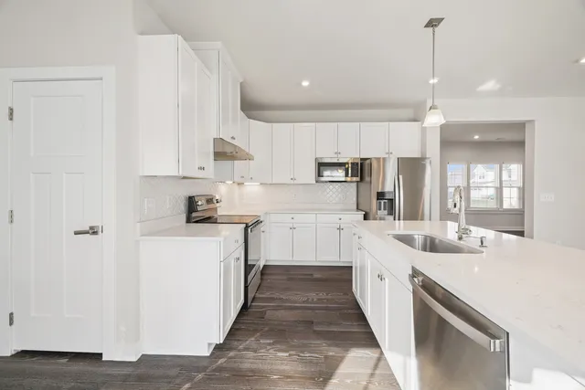 a kitchen with kitchen island white cabinets and white appliances