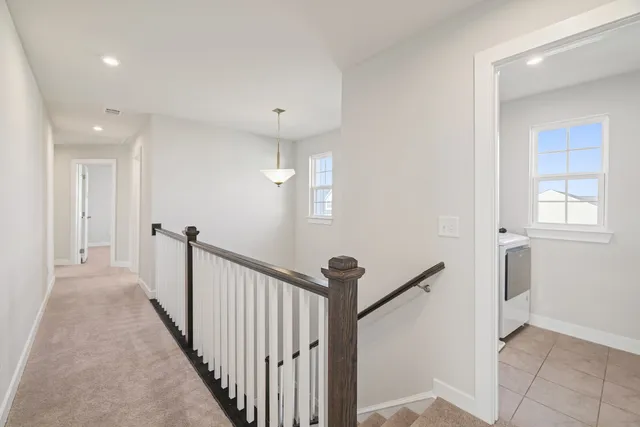 a view of a hallway with a window and stairs