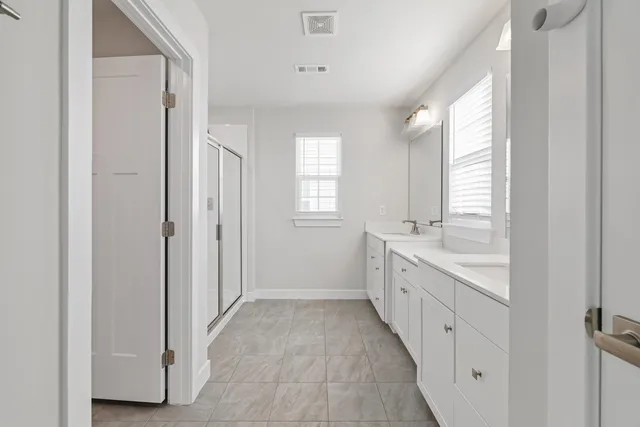a spacious bathroom with a granite countertop sink a mirror and a bathtub