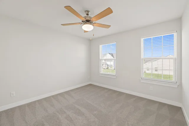 an empty room with a window and a fan
