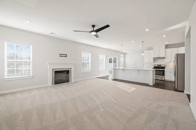 a view of empty room with kitchen and window