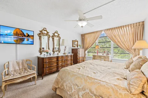 a bedroom with a bed and a large window