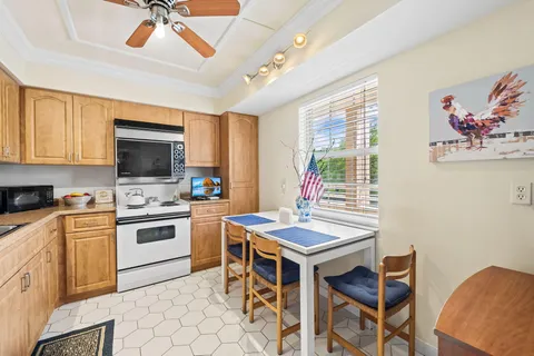 a kitchen with a stove a sink dishwasher a dining table and chairs with wooden floor