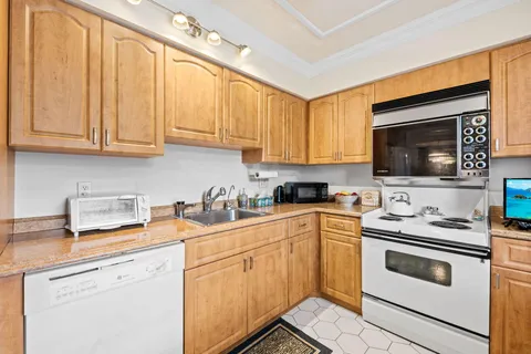 a kitchen with granite countertop white cabinets and white appliances